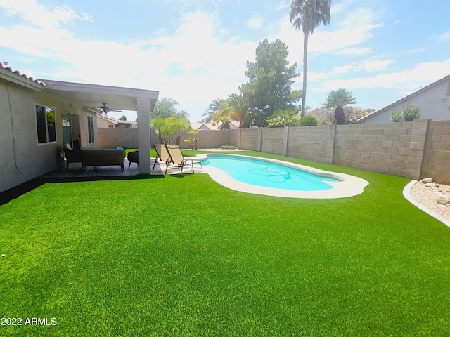 view of swimming pool with a fenced in pool, a patio, a fenced backyard, ceiling fan, and a yard