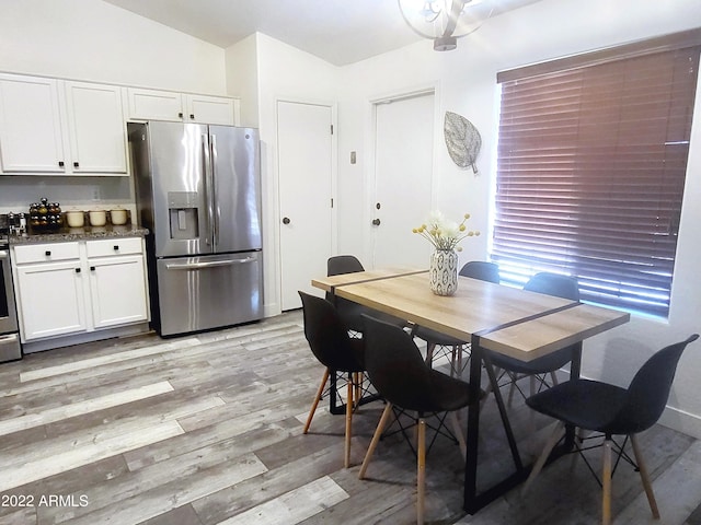 dining area with light wood-style flooring and baseboards