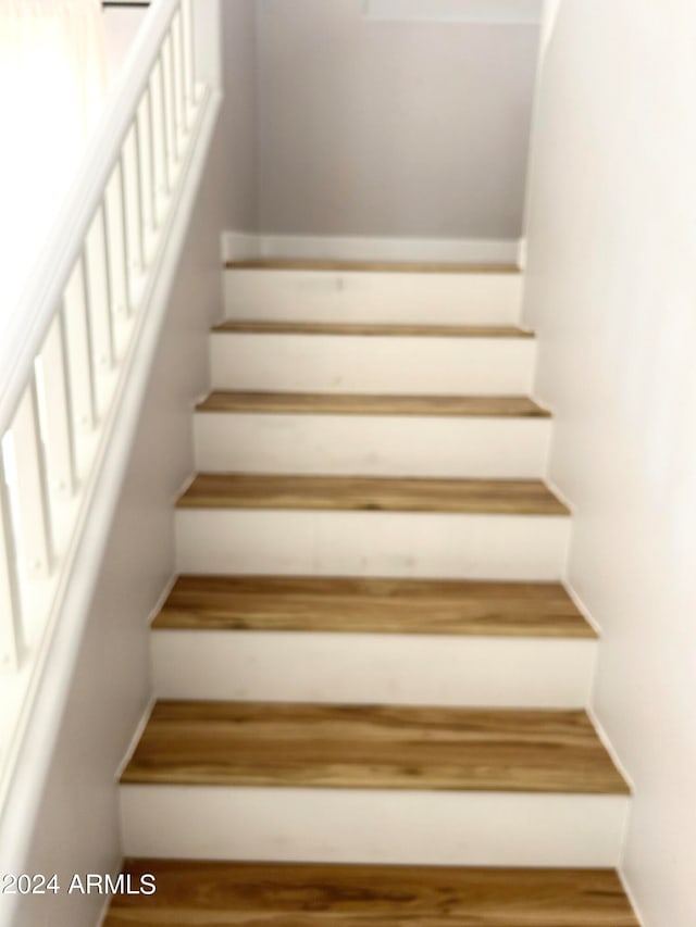 staircase with hardwood / wood-style flooring