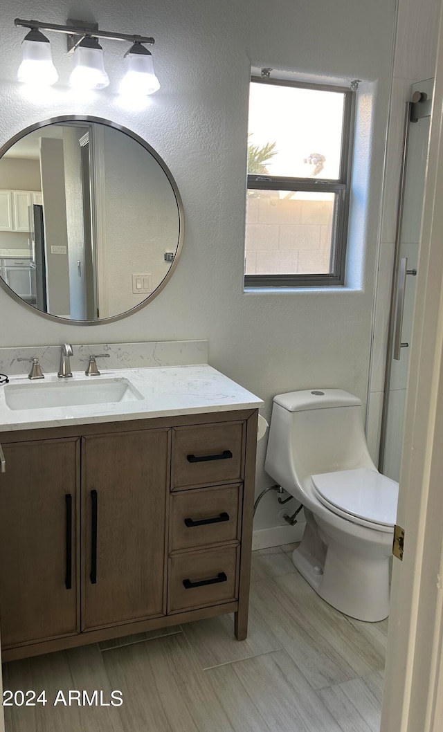 bathroom featuring washer / dryer, vanity, a shower, and toilet