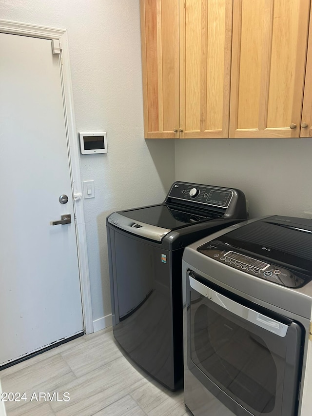 washroom with cabinets and separate washer and dryer