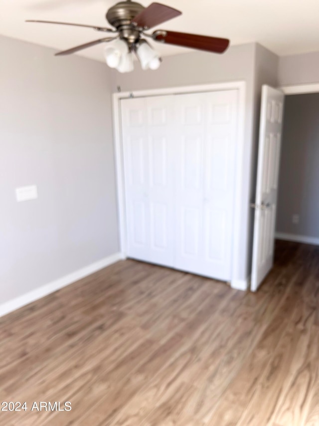 unfurnished bedroom with a closet, ceiling fan, and dark hardwood / wood-style floors