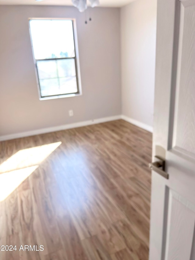 empty room with wood-type flooring and ceiling fan