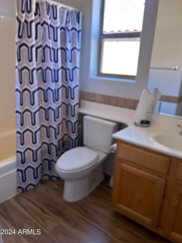 full bathroom with vanity, shower / bath combo, hardwood / wood-style flooring, and toilet