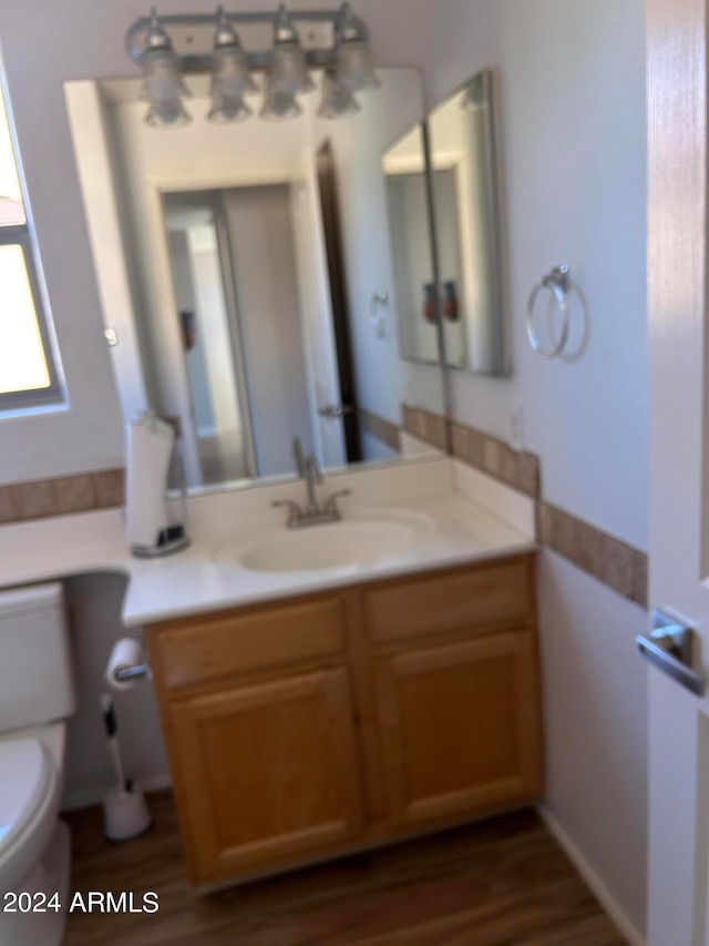 bathroom featuring vanity, hardwood / wood-style floors, and toilet