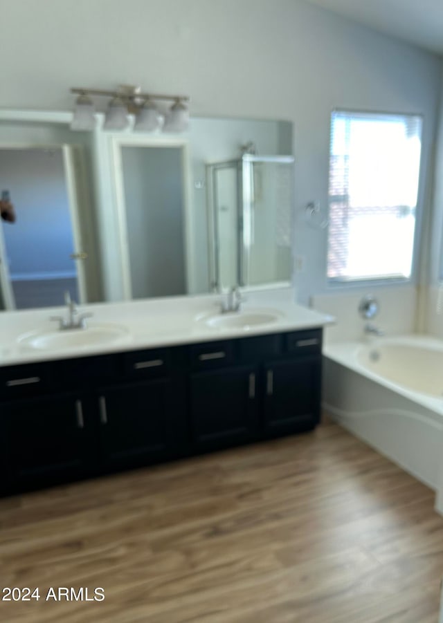 bathroom featuring vanity, hardwood / wood-style floors, plus walk in shower, and vaulted ceiling