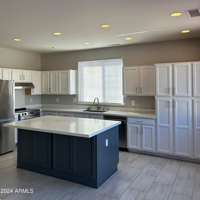 kitchen with a center island, white cabinetry, stainless steel appliances, and sink