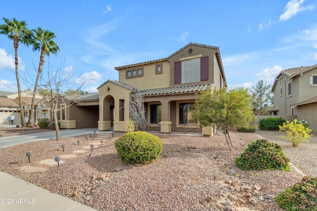 mediterranean / spanish-style house featuring a tile roof, a porch, concrete driveway, and stucco siding