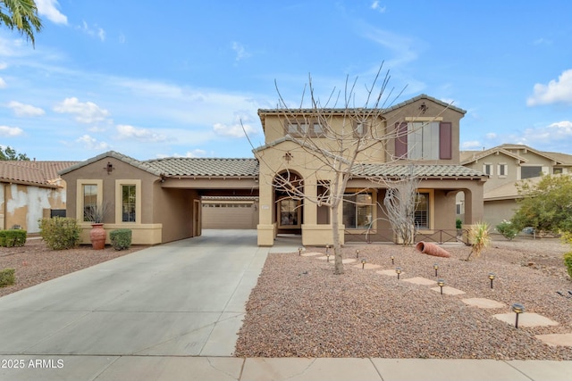 mediterranean / spanish-style house featuring driveway, an attached garage, a tiled roof, and stucco siding