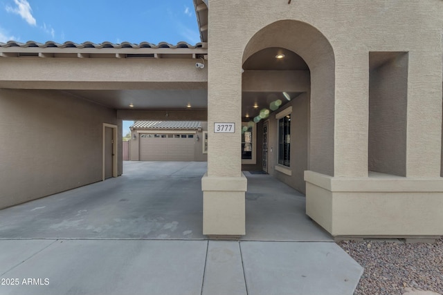 entrance to property featuring a tile roof and stucco siding