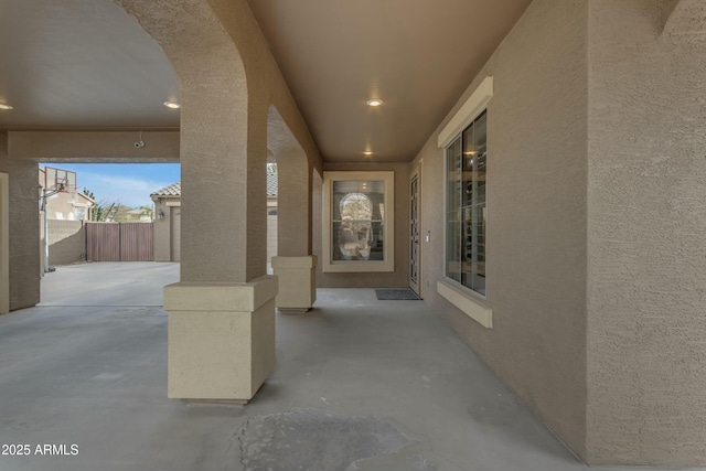 doorway to property featuring a patio, fence, and stucco siding