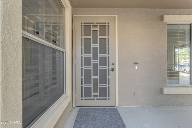 entrance to property featuring stucco siding