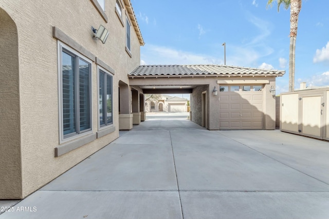 view of side of property with a tile roof and stucco siding