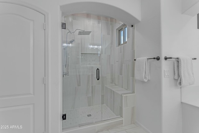 full bath featuring a stall shower and baseboards