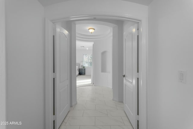 hallway with marble finish floor and baseboards