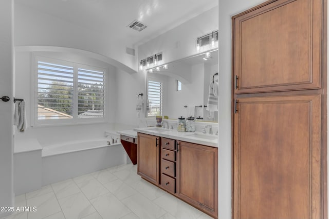 full bath featuring visible vents, a sink, a garden tub, and double vanity