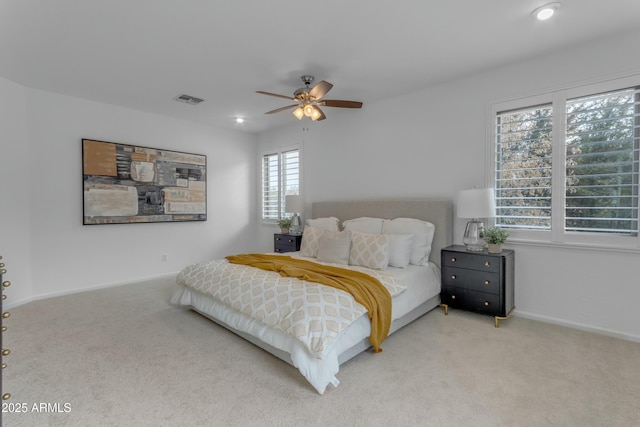 carpeted bedroom featuring a ceiling fan, visible vents, and baseboards