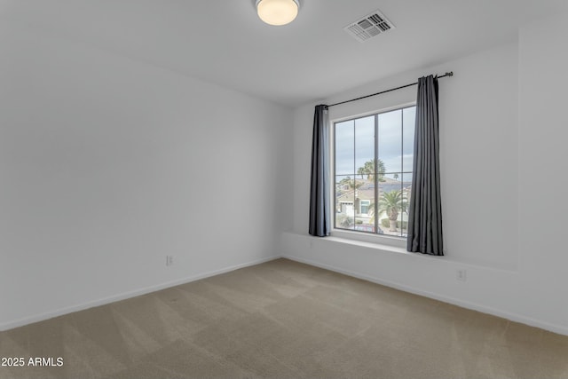 spare room with light carpet, baseboards, and visible vents