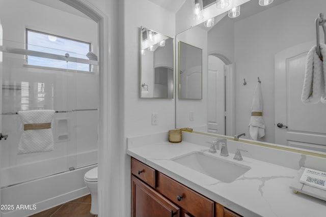 full bathroom with bath / shower combo with glass door, vanity, toilet, and tile patterned floors