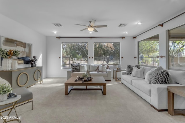 carpeted living room with visible vents and a ceiling fan