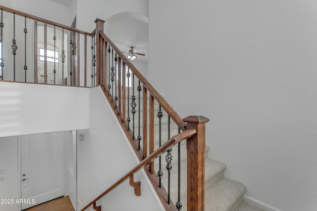 stairway with arched walkways and ceiling fan