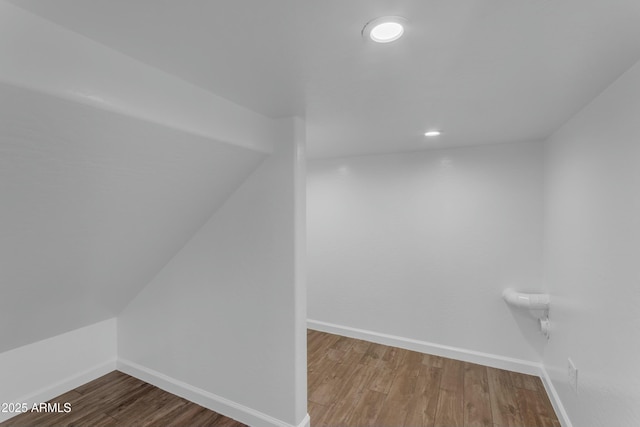 additional living space with wood finished floors and baseboards