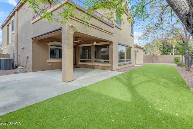 rear view of property featuring a patio, a fenced backyard, central air condition unit, a yard, and stucco siding