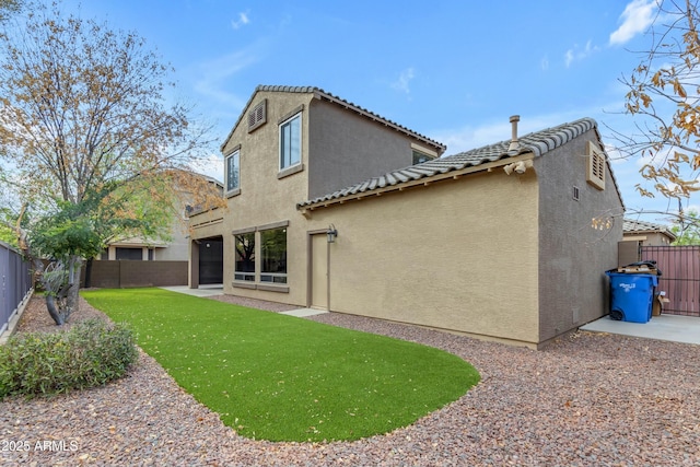 rear view of house featuring a patio, a lawn, a fenced backyard, and stucco siding