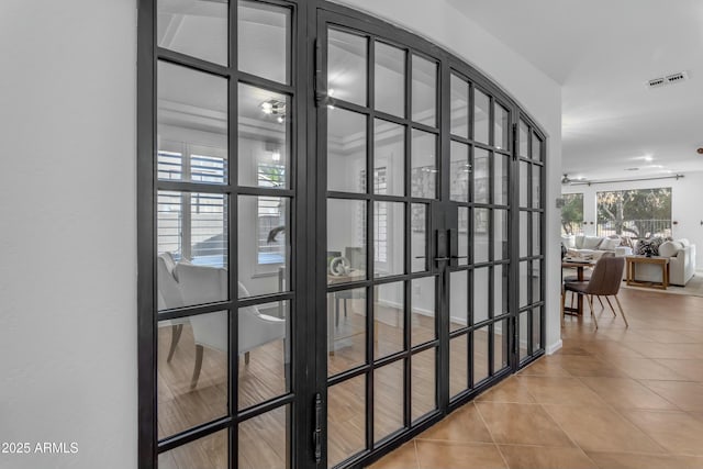 corridor with french doors, visible vents, and tile patterned floors