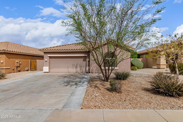 view of front facade with stucco siding, a garage, a tiled roof, and concrete driveway