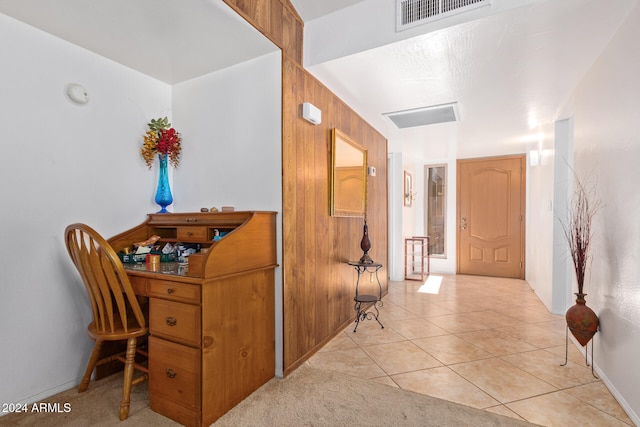 hallway featuring wood walls and light tile patterned floors