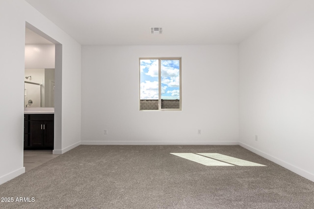 empty room with visible vents, baseboards, and light colored carpet