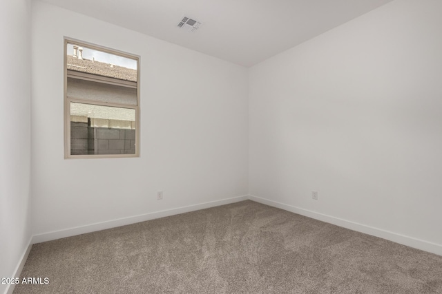 carpeted spare room with visible vents and baseboards