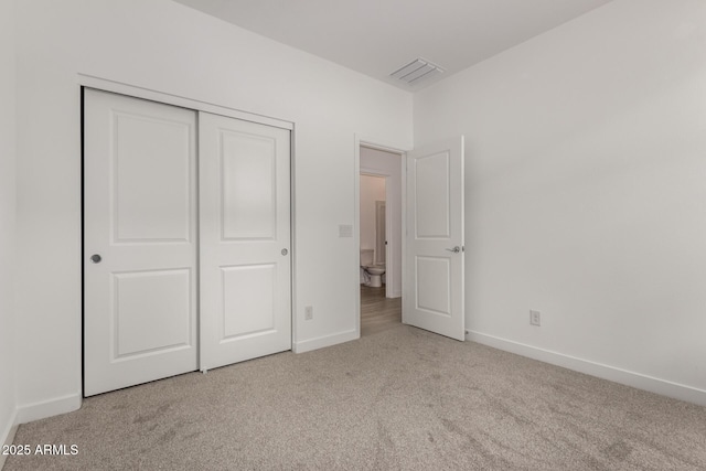 unfurnished bedroom featuring a closet, carpet flooring, baseboards, and visible vents