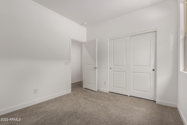 unfurnished bedroom featuring a closet, baseboards, and carpet floors