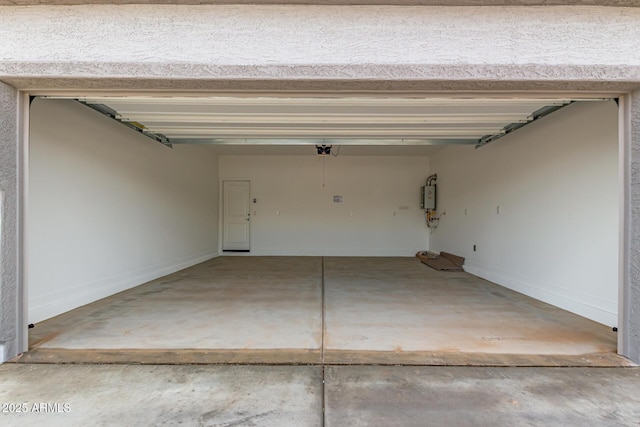 garage featuring a garage door opener, tankless water heater, and baseboards