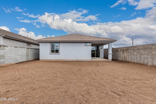 back of house with a patio area, stucco siding, a tiled roof, and a fenced backyard