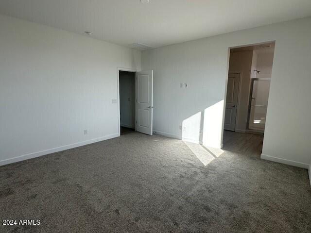 carpeted empty room with baseboards