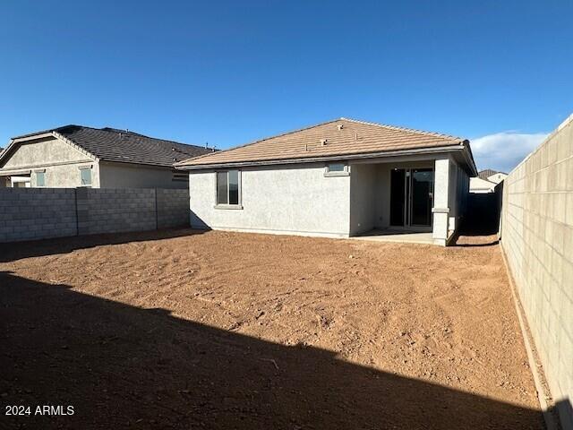 back of house with stucco siding and a fenced backyard