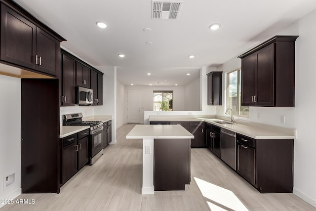 kitchen featuring visible vents, dark brown cabinetry, light countertops, appliances with stainless steel finishes, and light wood-style floors