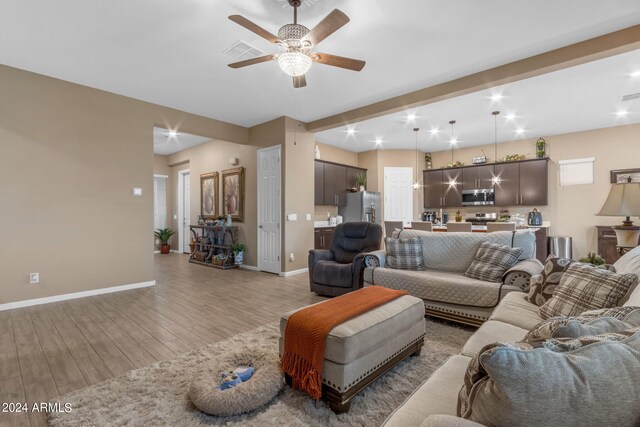 living room with light hardwood / wood-style floors and ceiling fan