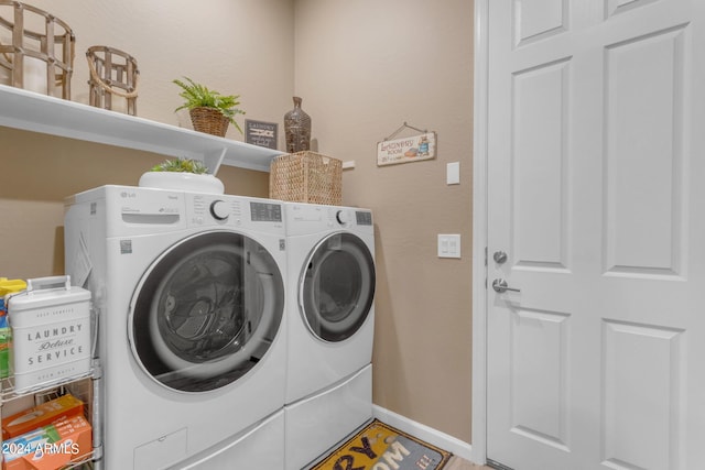 clothes washing area with washer and clothes dryer