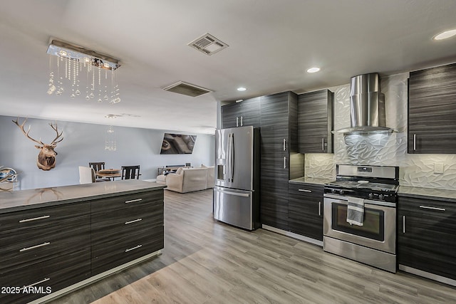 8137 E Indian School Rd, Scottsdale, AZ 85251 - kitchen featuring appliances with stainless steel finishes, wall chimney range hood, decorative backsplash, open floor plan, and modern cabinets
