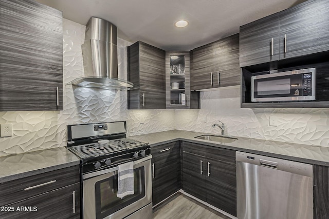 8137 E Indian School Rd, Scottsdale, AZ 85251 - kitchen featuring appliances with stainless steel finishes, wall chimney range hood, decorative backsplash, modern cabinets, and light wood-type flooring