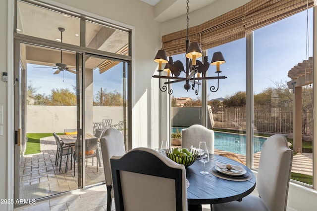 dining space with ceiling fan with notable chandelier