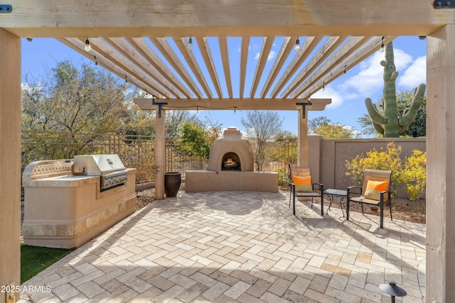 view of patio with area for grilling, exterior fireplace, a pergola, and grilling area