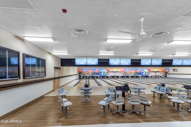 recreation room with hardwood / wood-style floors, a textured ceiling, and ceiling fan