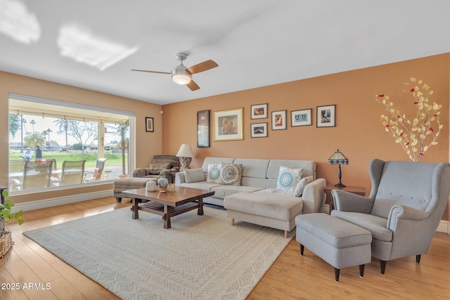 living room featuring ceiling fan and light wood-type flooring