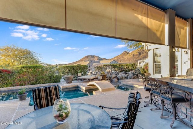 view of patio with a mountain view, a fenced in pool, and a bar