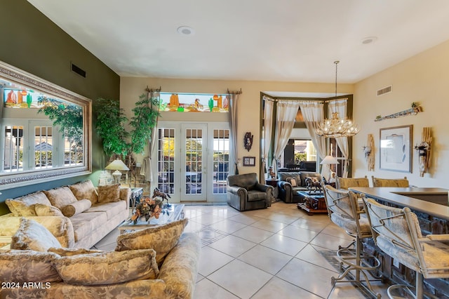 tiled living room featuring a chandelier and french doors